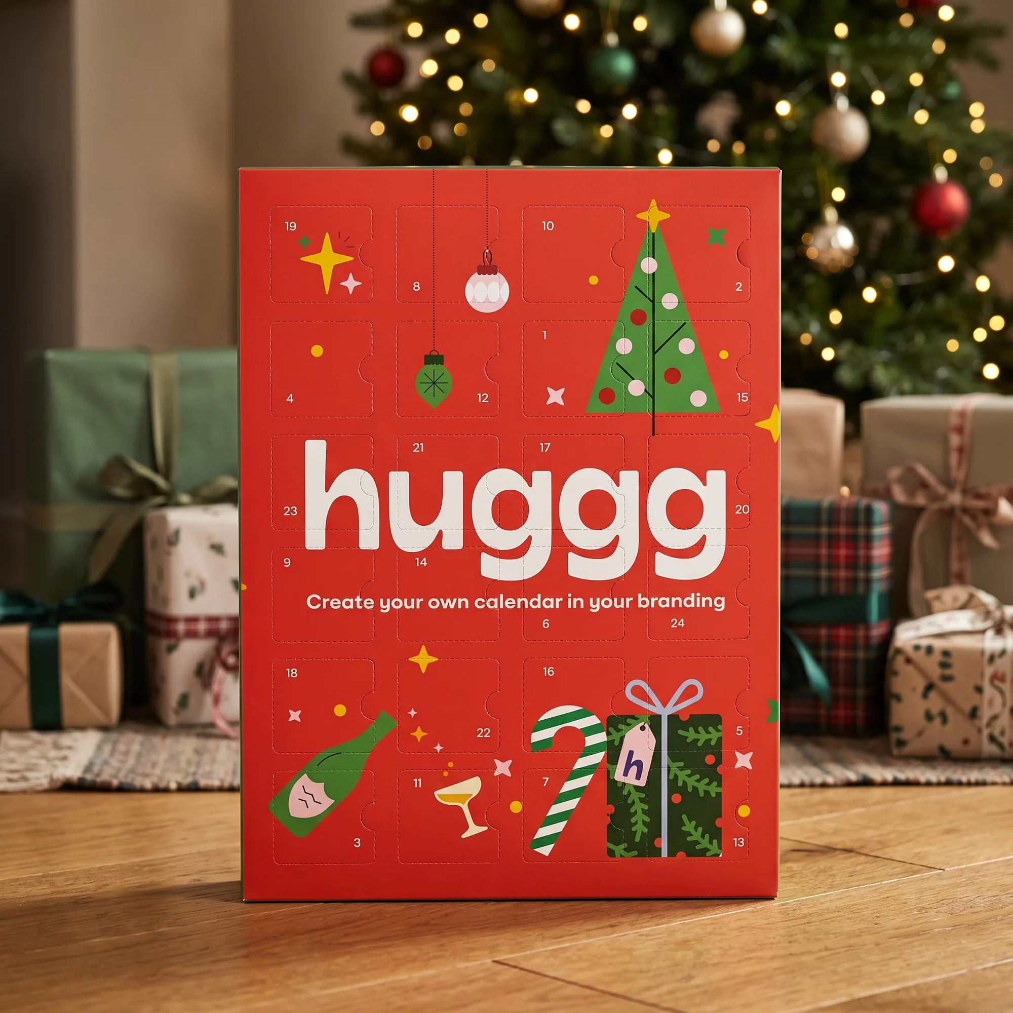 A Huggg branded chocolate advent calendar standing in front of a decorated Christmas tree, with the tagline Create your own calendar in your branding