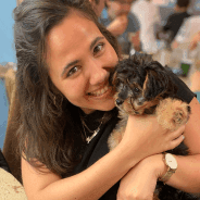 A smiling woman holding a puppy